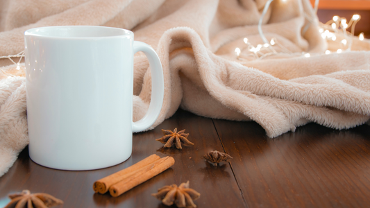 coffee mug and cinnamon sticks on a wooden table with christmas lights