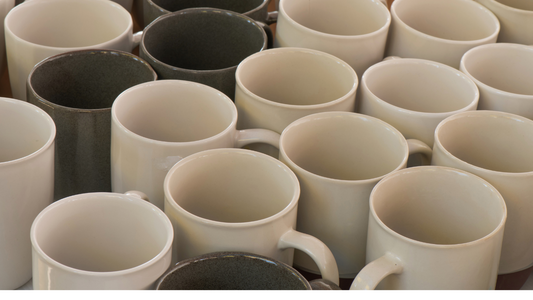 many coffee mugs are lined up on a table