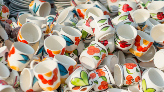 a pile of cups and saucers with colorful designs