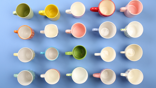 many different colored cups and saucers are arranged on a blue background