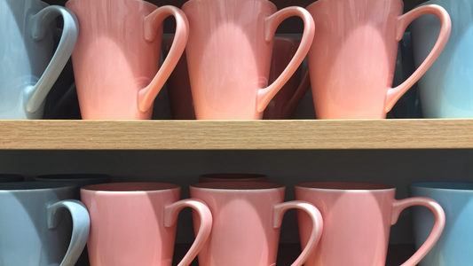 many different colored mugs are on a shelf