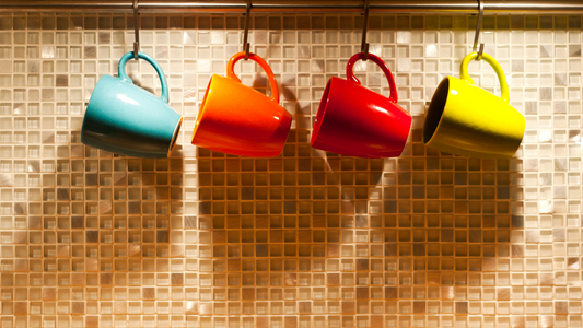 colorful coffee mugs hanging on a rack in a kitchen