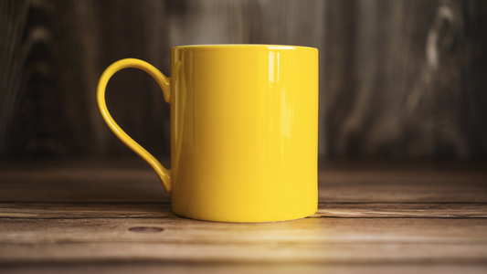 a yellow mug sitting on top of a wooden table