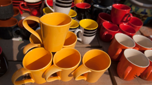 many different colored coffee cups and mugs sitting on top of each other