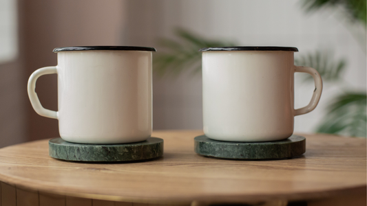 two coffee mugs sit on top of a wooden table