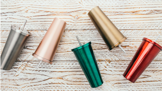 Four different colors of tumblers on a wooden table