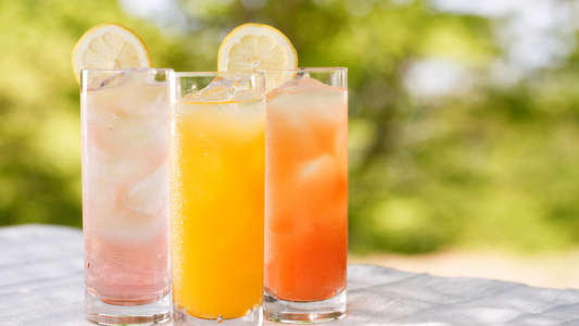 three different colored drinks in glasses on a table